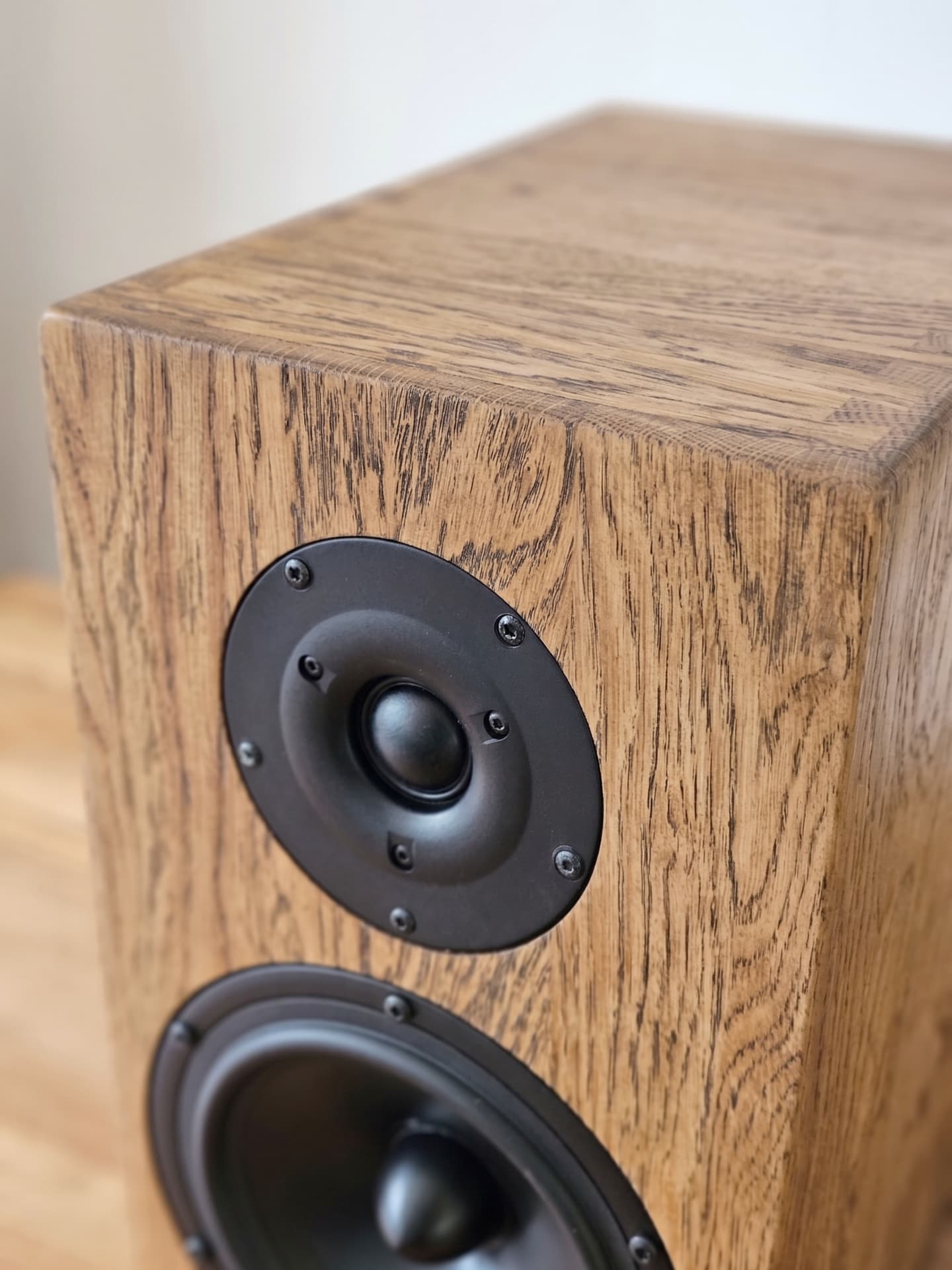Close-up of a Haient Haven loudspeaker cabinet in oak, showing tweeter and woofer detail